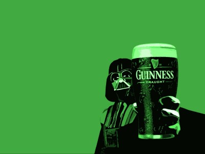 A stylized black and green Darth Vader raises a Guinness