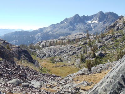 The start of the descent past Shadow Lake toward Devils Postpile; far in the distance lies the black Volcanic Ridge